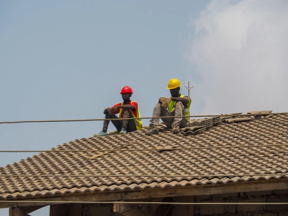two men sitting on a roof